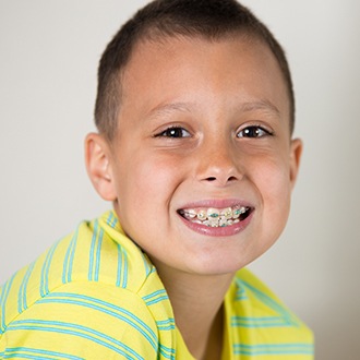 Young boy smiling during pediatric orthodontic treatment